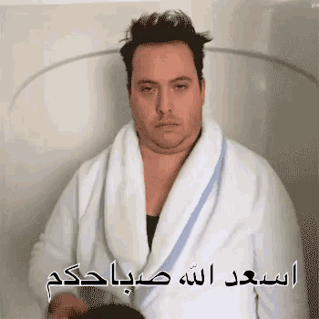 a man in a bathrobe is sitting in a bathtub