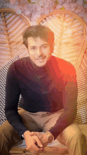 a man in a black turtleneck sits in a chair