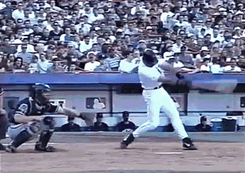 a baseball player swings a bat at a ball while a catcher watches