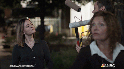 a woman holding a paint roller with the nbc logo on the bottom right