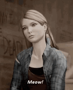 a woman in a plaid shirt is sitting down and saying `` meow '' .