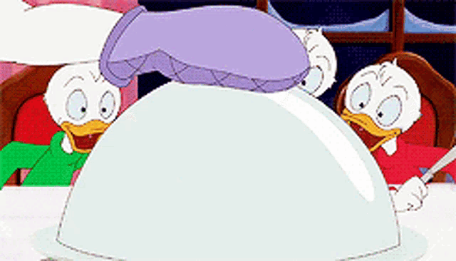 donald duck and daisy duck are sitting at a table with a turkey on a plate .