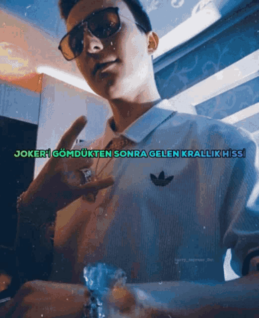 a man wearing sunglasses and a white shirt with the word joker on it