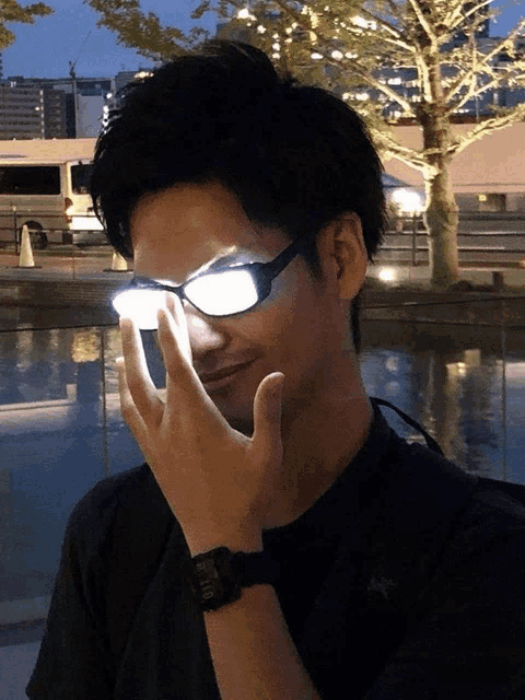 a man wearing a watch and a pair of glasses with a light coming out of them