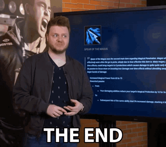 a man is standing in front of a large screen that says the end