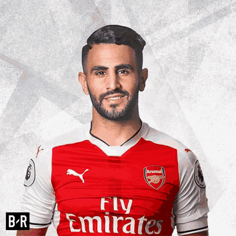 a man with a beard is wearing a red fly emirates jersey