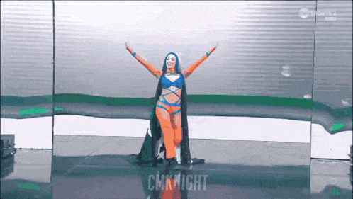 a woman in a superhero costume is standing on a stage with her arms outstretched and the words cmknight behind her