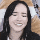 a close up of a woman smiling with her eyes closed and wearing headphones .