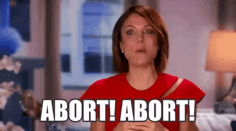 a woman in a red dress is standing in front of a window and says abort ! abort !