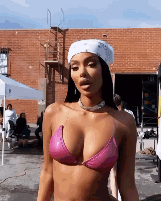 a woman wearing a pink bikini and a white bandana