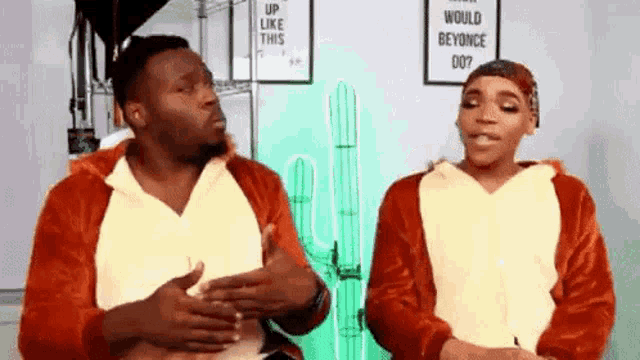 a man and a woman are standing next to each other in pajamas and talking to each other .
