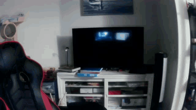 a black and red chair sits in front of a television that says 1:27 on it