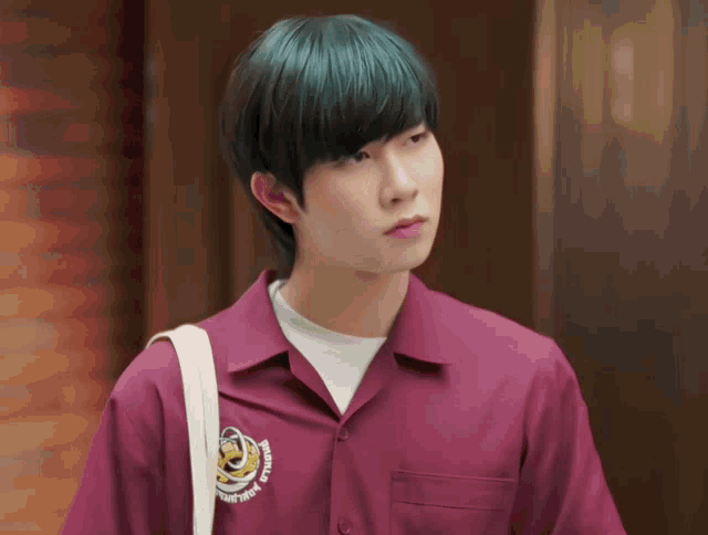 a man with green hair wears a purple shirt that says " people " on the front