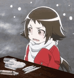 a little girl in a red jacket is sitting at a table