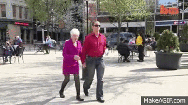 a man and a woman are walking down a city street .