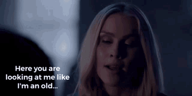 a woman is talking to another woman in a dark room .