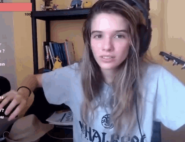 a woman wearing headphones and a t-shirt that says " whale " on it