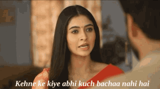a woman in a red saree is talking to a man with the words kehne ke kiye abhi kuch bachaa nahi hai