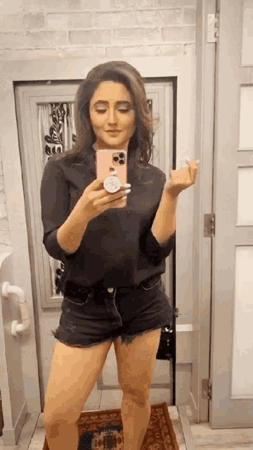 a woman taking a picture of herself in front of a mirror