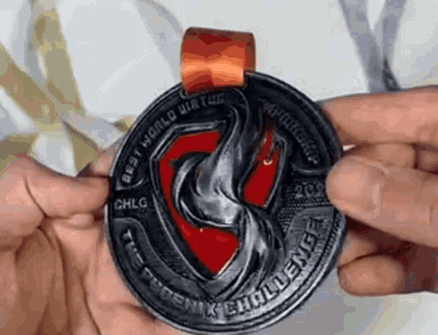 a person is holding a medal that says phoenix challenge