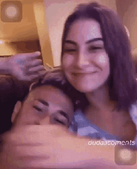 a man and a woman are hugging each other in a video .