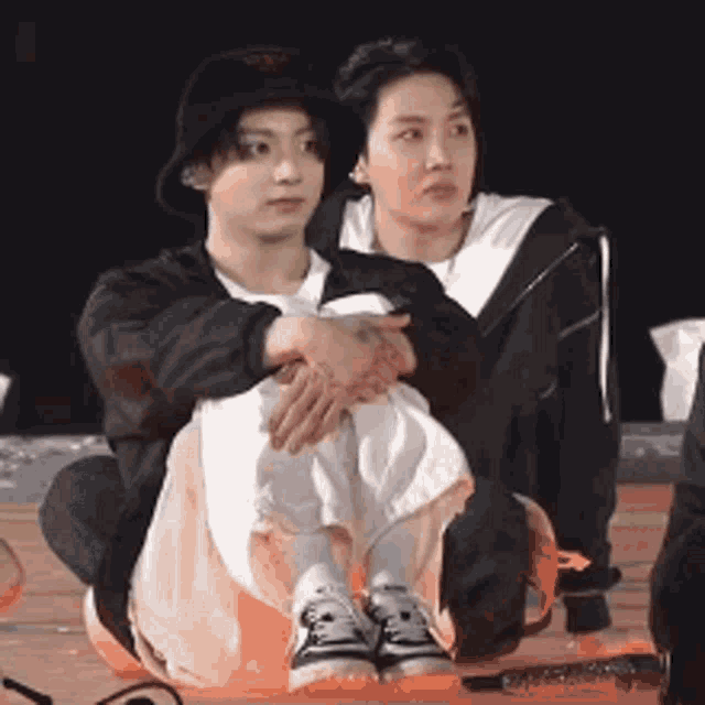 a man and a woman are sitting next to each other on the ground .