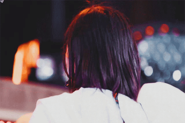 a woman 's back is shown in a blurry photo with the letter a in the background