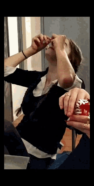 a woman is holding a can of coca cola in her hand