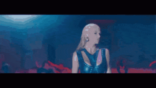 a blurry picture of a woman dancing in front of a crowd of people