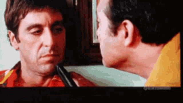 two men are looking at each other and one has a gun