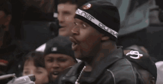 a man wearing a black beanie with a white band that says king gunka