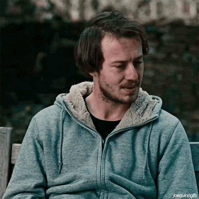 a man with a beard wearing a grey hoodie with joequinngifs written on the bottom