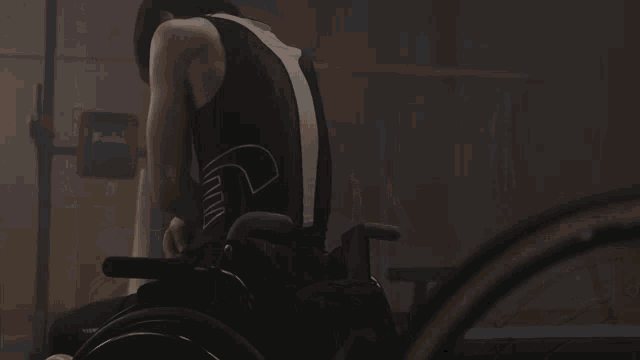 a person in a wheelchair is wearing a tank top that says nike on the back