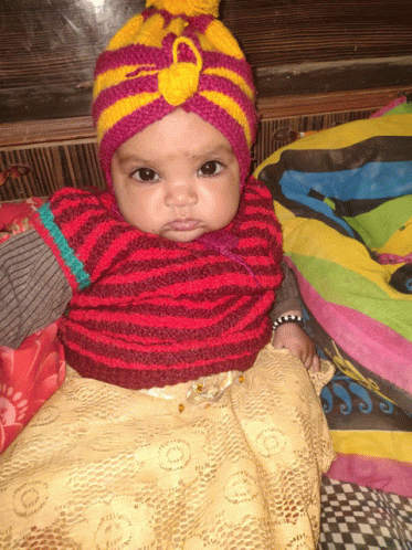 a baby wearing a red and yellow striped sweater