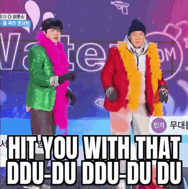 two men dancing in front of a sign that says " hit you with that ddu-du ddu-du-du-du "