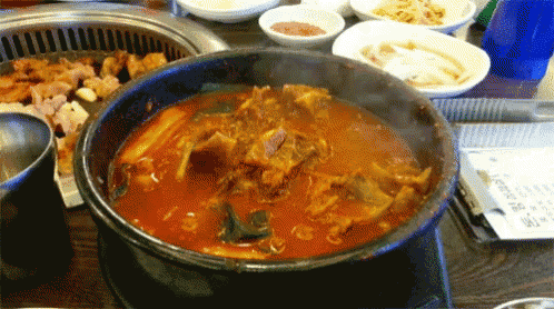 a bowl of stew with meat and vegetables is on a stove
