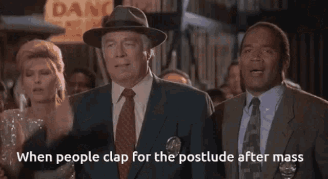a group of men in tuxedos are sitting at a desk with a caption that says when people clap for the postlude