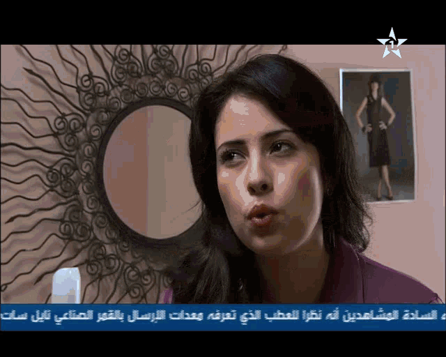 a woman stands in front of a mirror with a picture of a woman on the wall