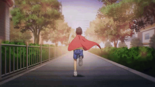 a boy with a red cape is running down a street