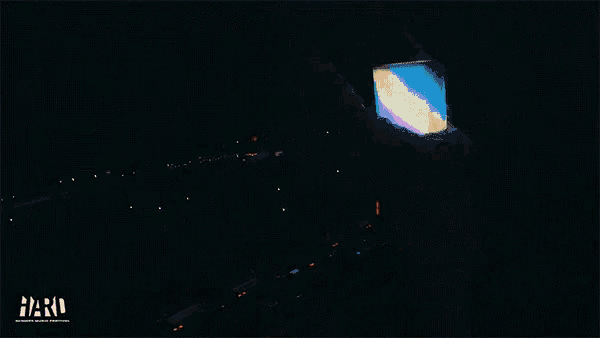 a dj stands in front of a crowd with fireworks behind him and the word hard on the bottom