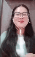 a woman wearing glasses and headphones is making a face .