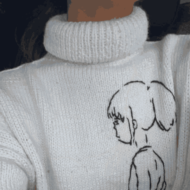 a woman wearing a white sweater with a drawing of a girl on the front