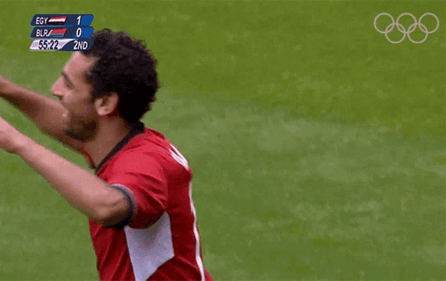 two soccer players hugging each other with a scoreboard in the background that says egy 1 blr 0 2nd