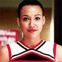 a cheerleader is wearing a red , white , and black uniform .