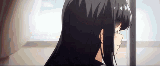 a girl with long black hair is standing in front of a window .