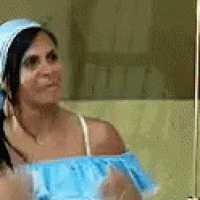 a woman wearing a blue off the shoulder top is looking at herself in a mirror .