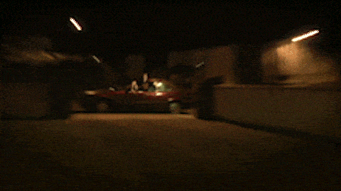 a blurry picture of a red car with a yellow light in the background