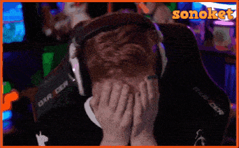 a man wearing headphones covering his face with his hands .