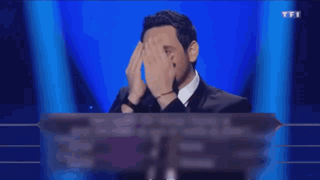 a man in a suit and tie is behind a sign that says tfi on it
