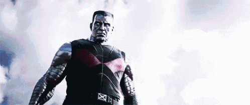 a man in a superhero costume is standing in front of a cloudy sky looking up .